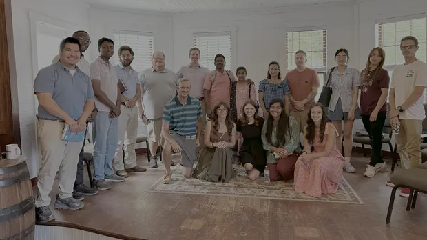 Adults gathered around tables in a Sunday School classroom at Sauldam.