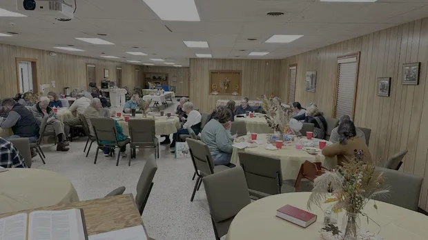 Church members eating supper together at long tables in the Sauldam fellowship hall.